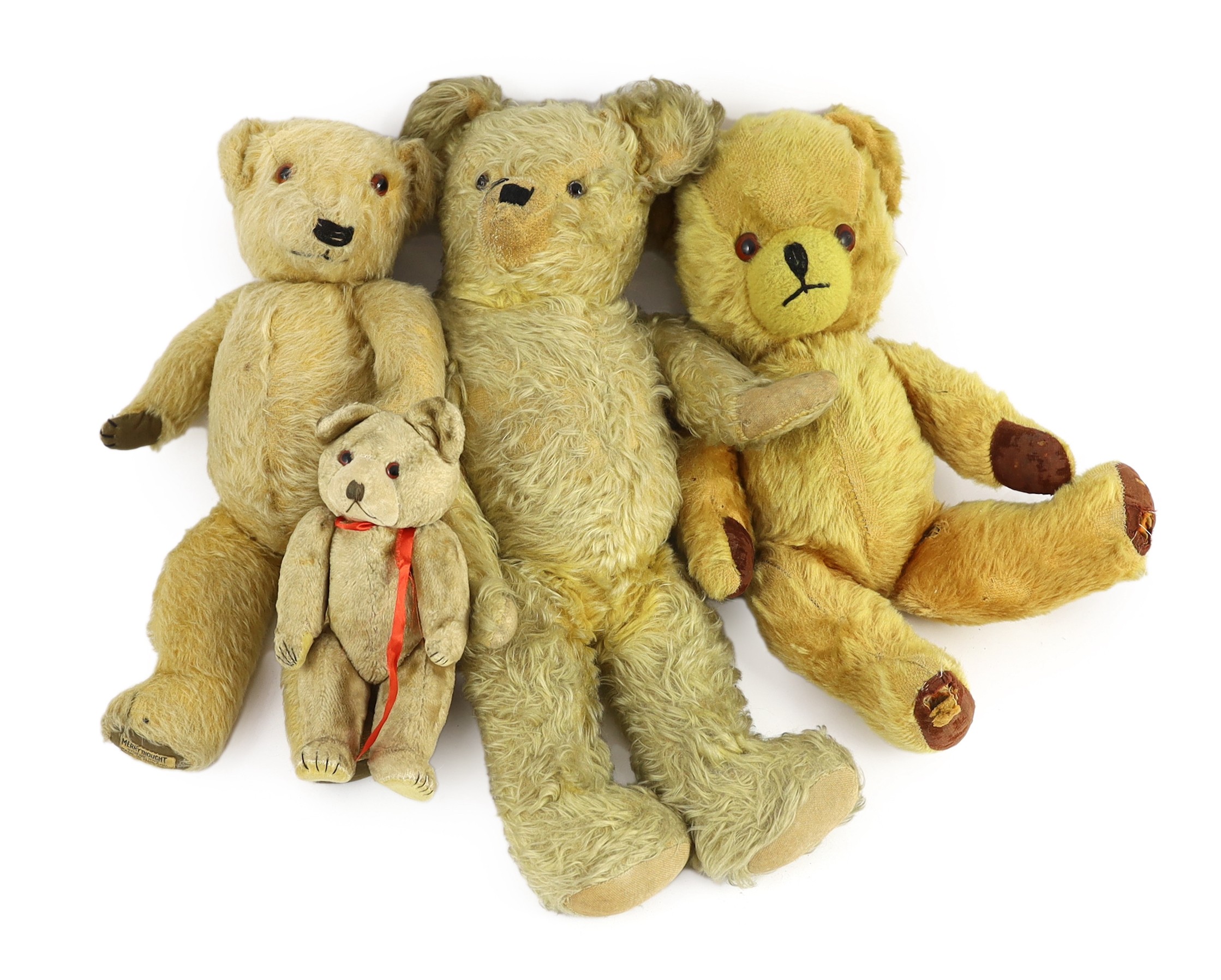 A blonde plush Teddy bear, glass eyes and shaved snout, 18in., and three other Teddy bears